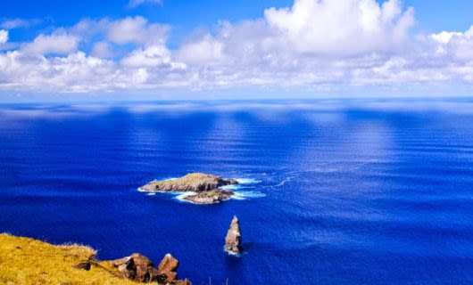 Rocks of Moto Nui Islet in blue ocean
