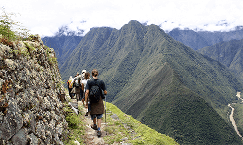 A group hiking the Inca Trail through the mountains and clouds