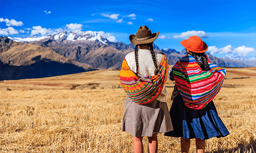 Two native Peruvian girls looking off into the mountains