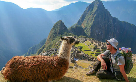 tourist sitting at machu picchu ruins